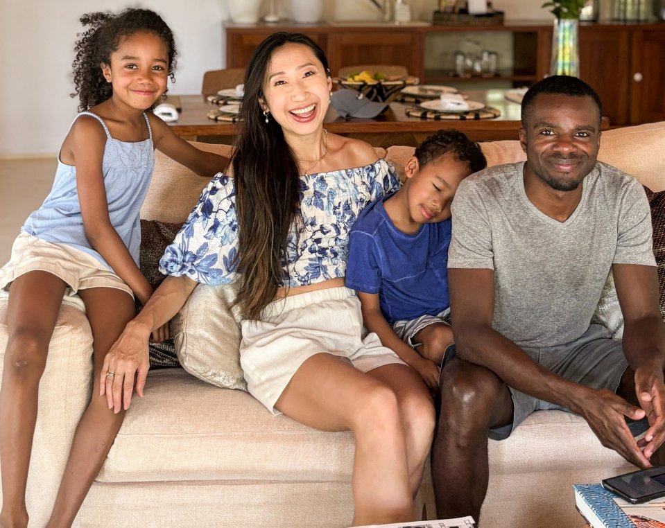 A family of four sits on a couch.