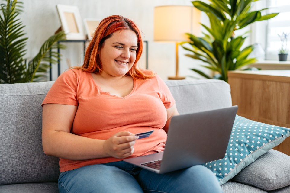 Smiling plus-size woman online shopping on her laptop.