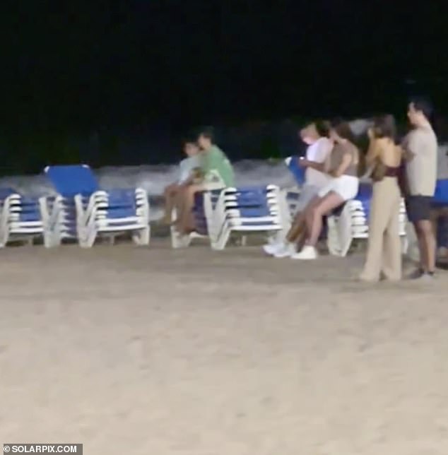 Members of the public are pictured at the scene after police worked to recover the body