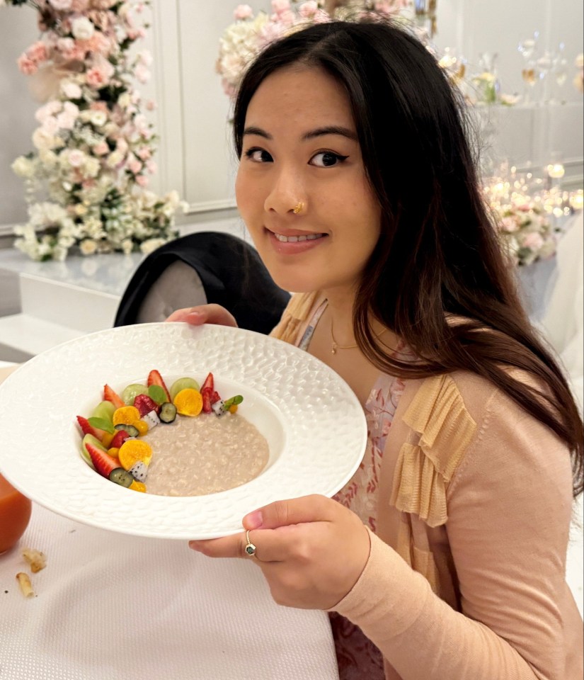 Woman holding a bowl of oatmeal topped with fruit.