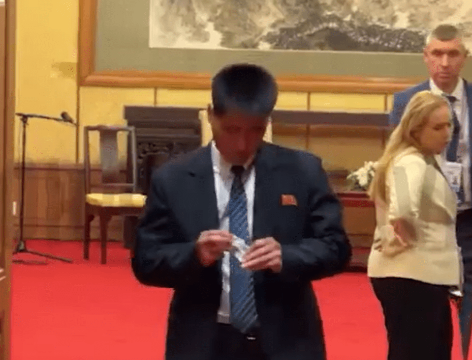 Man in suit handling something small.