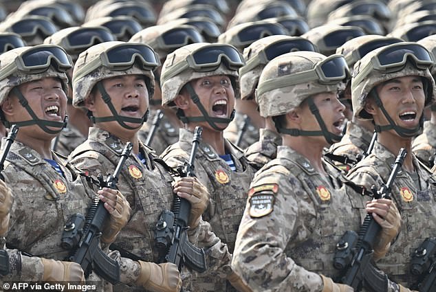 Chinese soldiers carry assault rifles with optical zooms during the procession on Wednesday