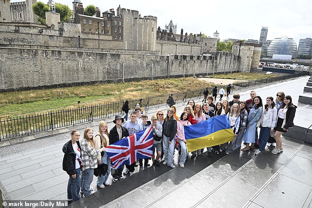 The children unfurled two flags as they posed for this photo for the Daily Mail outside the Tower of London