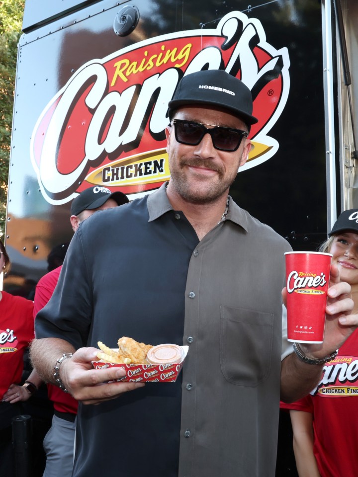 Man holding Raising Cane's chicken fingers and drink.