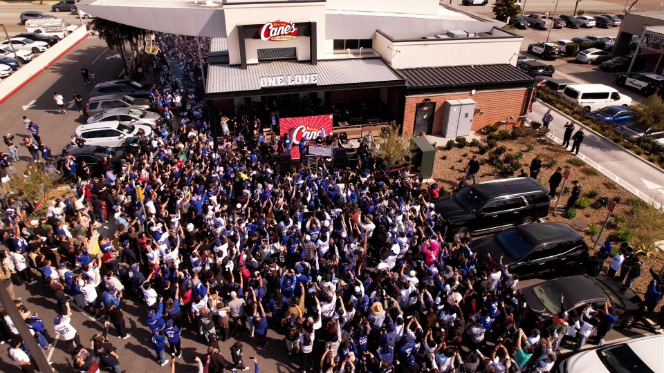 Large crowd at Raising Cane's Chicken Fingers restaurant grand opening.