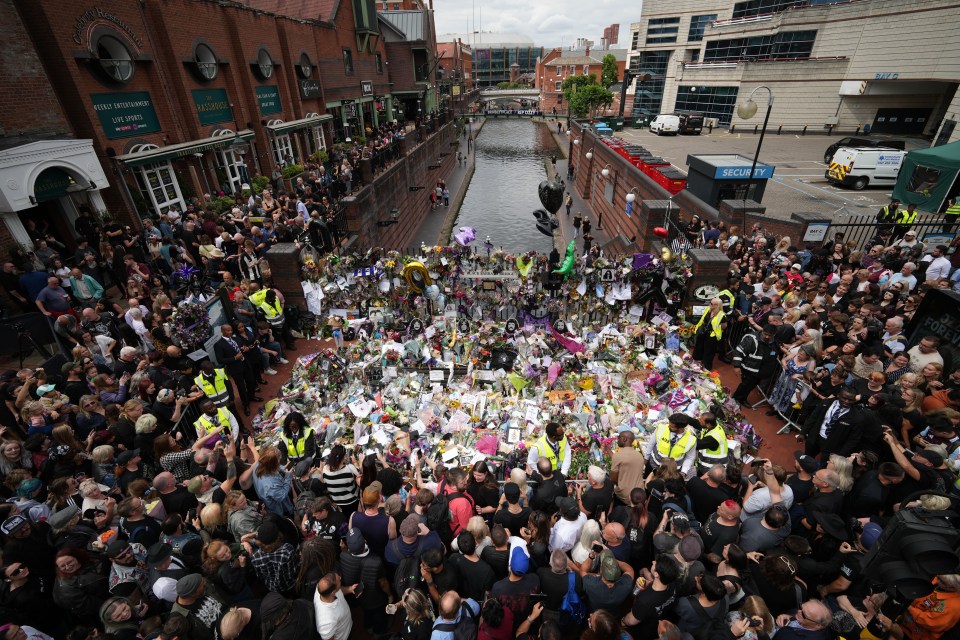 Mourners gather at a memorial for Ozzy Osbourne in Birmingham, England.