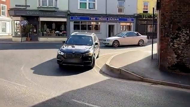 Pictured: A driver attempts the tight corner where the raised kerb has caused damage to others