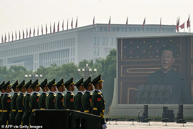 China's President Xi Jinping is seen on a big screen as he delivers a speech at the start of a military parade