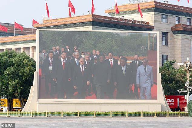 A screen shows Russia's President Vladimir Putin (C-L), Chinese President Xi Jinping (C) and North Korea's leader Kim Jong Un (C-R)