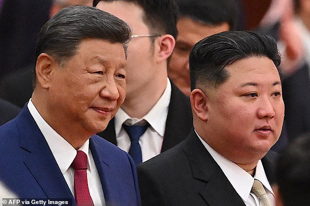 China's President Xi Jinping (L) and North Korea's leader Kim Jong Un arrive for a reception in the Great Hall of People