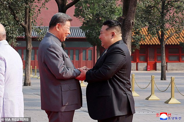 North Korean leader Kim Jong Un shakes hands with Chinese President Xi Jinping as they attend a military parade marking the 80th anniversary of the end of World War Two