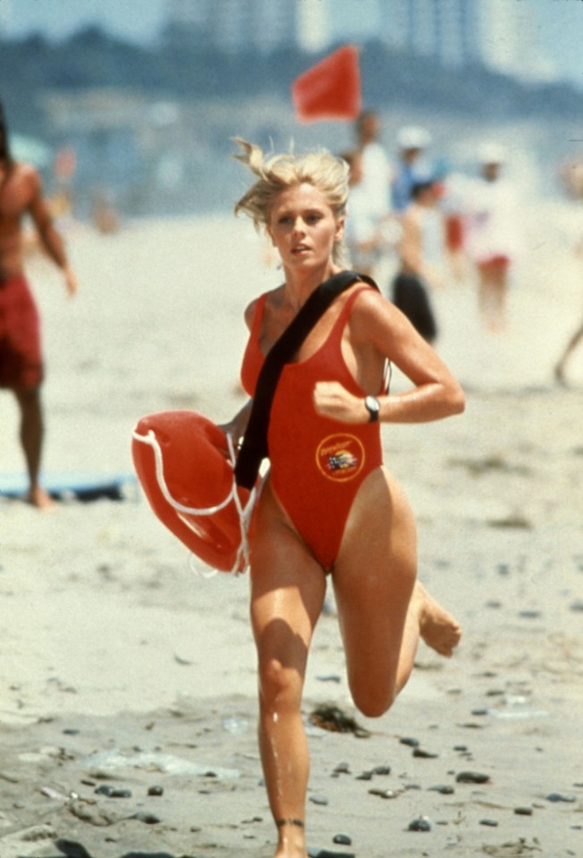 Nicole Eggert as Summer Quinn in Baywatch running on a beach.