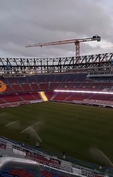 Stadium under construction with crane.