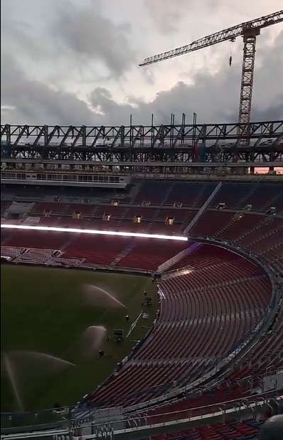 Stadium under construction with sprinklers on the field.