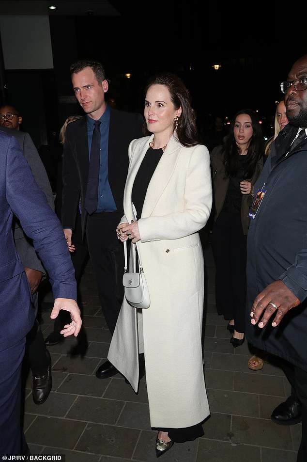Arriving for the afterparty, Michelle changed outfit and sported a comfortable long black dress that she paired with a white long coat