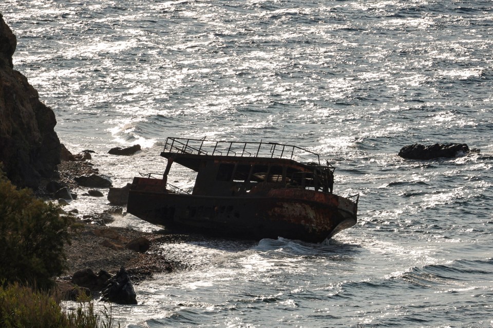 Shipwreck of a boat used by refugees on a shore.
