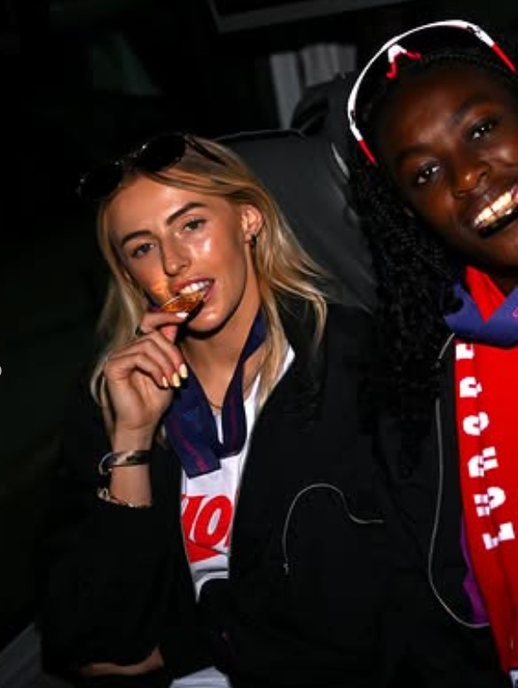 Two athletes celebrating with a gold medal.