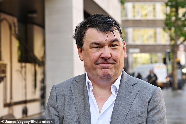 The Father Ted creator smiled and posed for photographers, wearing a grey suit and a white shirt
