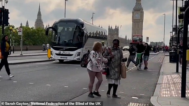 A cyclist is seen weaving through pedestrians at a crossing near Westminster