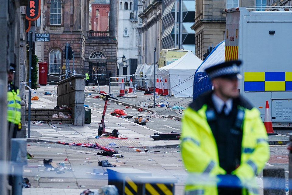 Police tents and debris at a Liverpool city center scene.