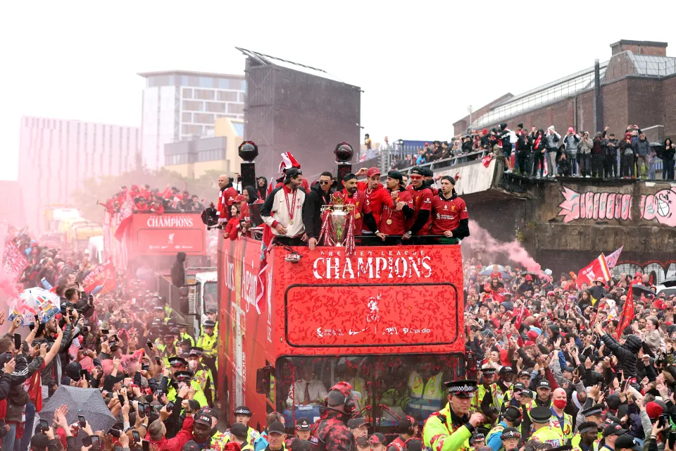 Liverpool players celebrating Premier League victory on an open-top bus.