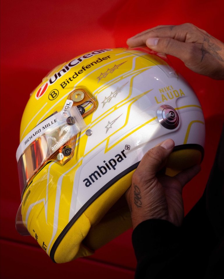 Lewis Hamilton holding Niki Lauda tribute helmet.