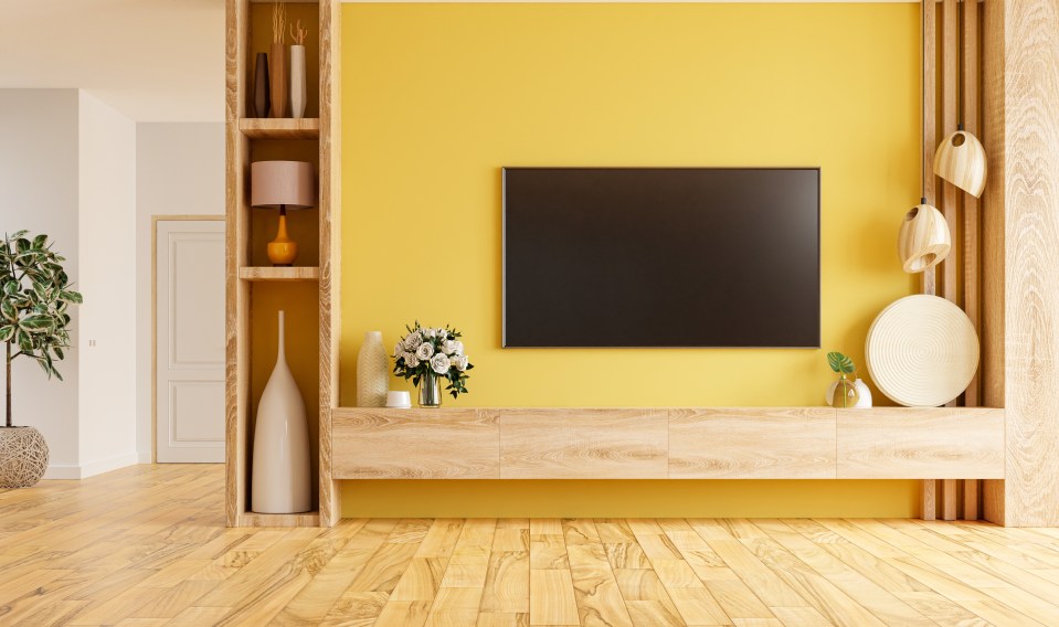 Illustration of a modern living room with a yellow wall, wood shelving, and a flat-screen TV.