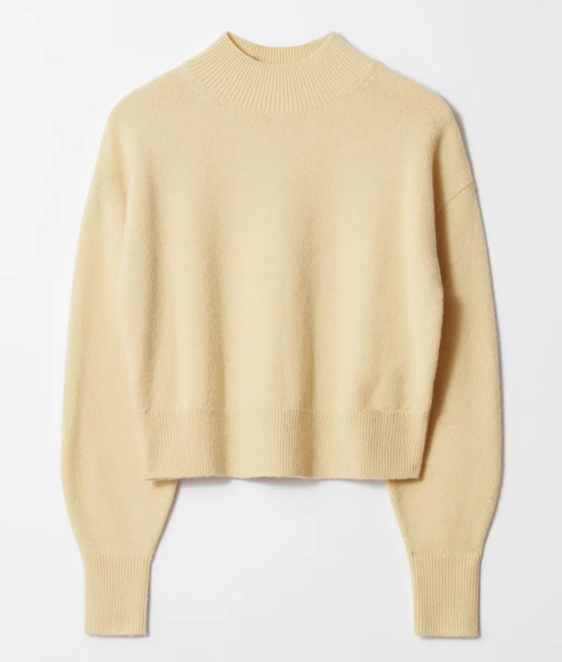 Pale yellow mock neck sweater.