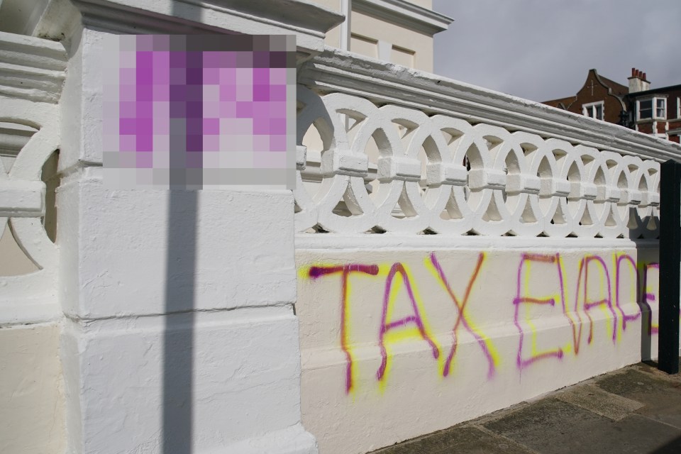 Graffiti reading "TAX EVADE" on a wall.