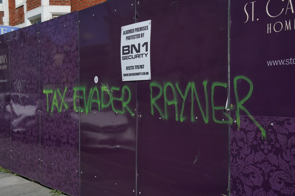 Graffiti reading "Taxevader Rayner" on a purple wall.