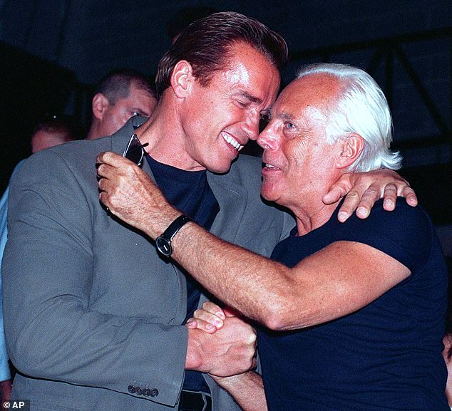 Actor Arnold Schwarzenegger hugs Italian fashion designer Giorgio Armani at the end of Emporio Armani's Spring-Summer 1999 Men's collection Fashion Show in Milan, June 29 1998