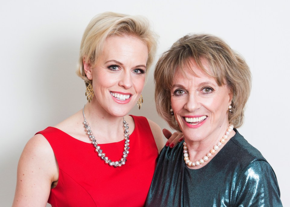 two women are posing for a picture and one is wearing a pearl necklace