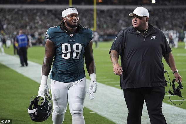Carter walks off the field with Eagles' head of security Dom DiSandro after being ejected
