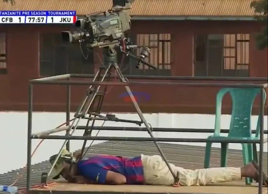 A person lying on the ground during a football match disruption caused by a swarm of bees.