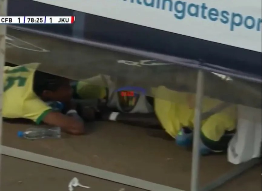 Soccer players taking cover from a swarm of bees.