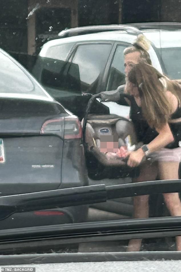 The post comes just after the Hensels were photographed carrying a baby car seat outside a Minnesota school where they teach fifth grade. Pictured: The twins seen loading a baby into the back of their black Tesla before driving away in mid-August 2025