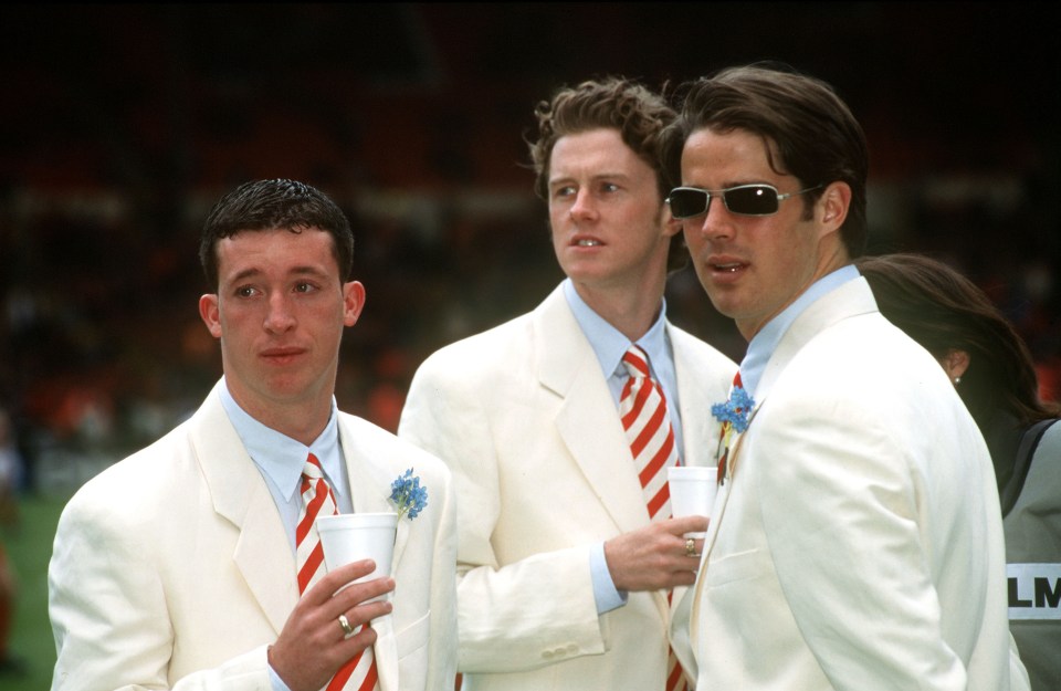Liverpool footballers Robbie Fowler, Steve McManaman, and Jamie Redknapp in white suits at the 1996 FA Cup Final.