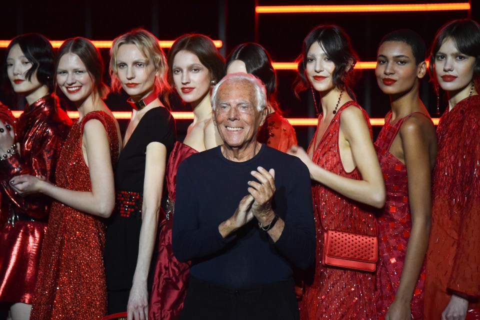 Giorgio Armani applauds after a fashion show.