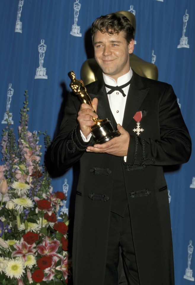 Russell Crowe holding an Academy Award.