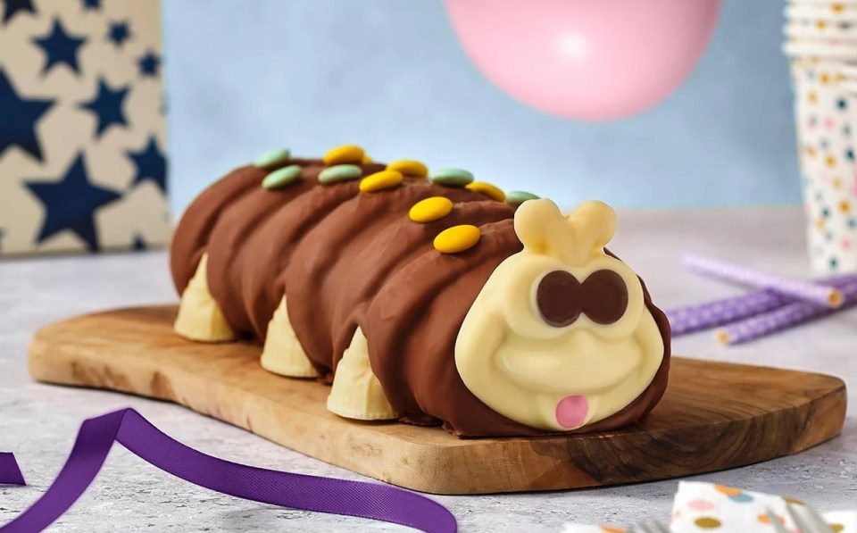 Chocolate caterpillar cake decorated with colorful candies.