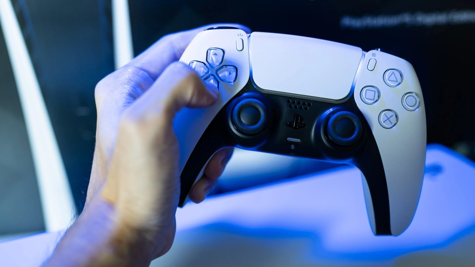 Person holding a PlayStation 5 DualSense controller.