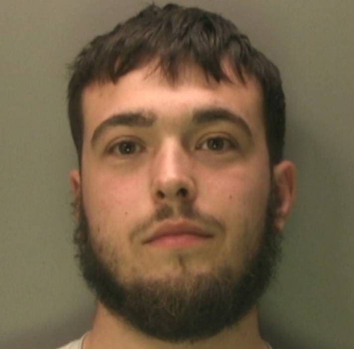 Mugshot of a young man with short brown hair and a beard.