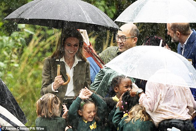 The Princess appeared firmly in her element despite the rain shower, as she was seen laughing amid the delighted children