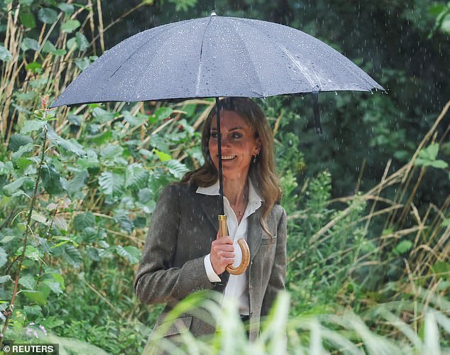 At one point, the Princess was seen smiling as she took shelter from the rain under a black umbrella