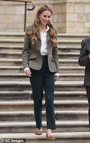 She paired the look with a white shirt and dark green tailored trousers
