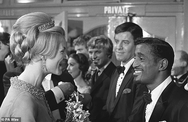 The Duchess of Kent smiling with American comedian Sammy Davies jnr, when the stars were presented after the Royal Variety Show at the London Palladium. Jerry Lewis (centre) and Tommy Steele look on