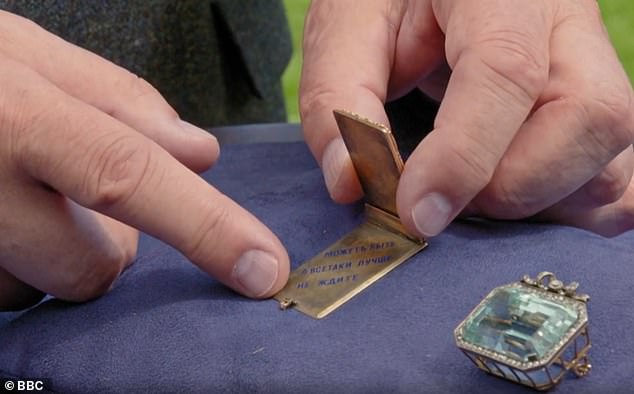 The pendant, the expert explained, was set with diamond initials over a sunburst geocache design and inscribed in Cyrillic with the phrase 'Maybe it's better not to wait'