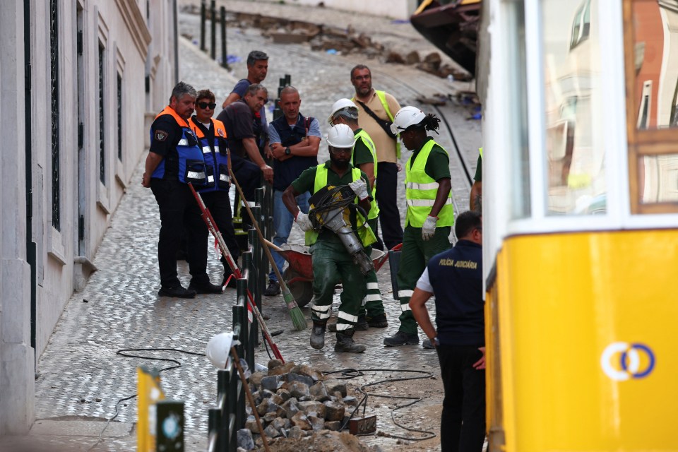 Workers clearing debris at the site of a funicular railway accident.