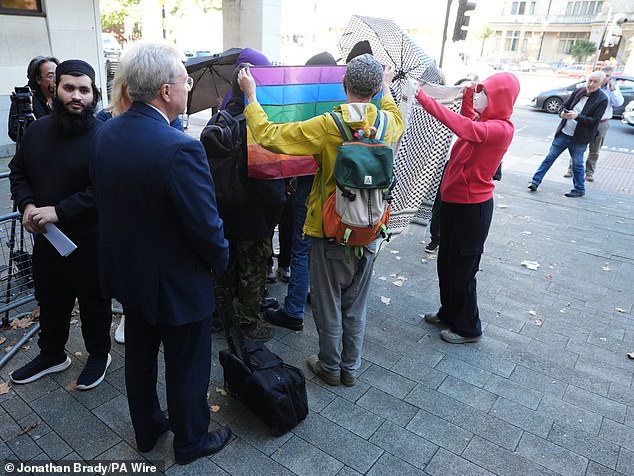 Sophia Brooks was shielded by activists with umbrellas, rainbow flags and what appeared to be a Palestinian keffiyeh-style scarf