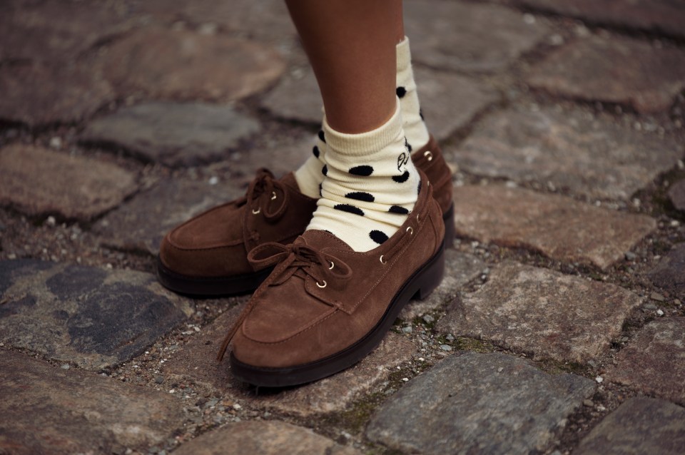 Brown loafers and cream socks with black polka dots.